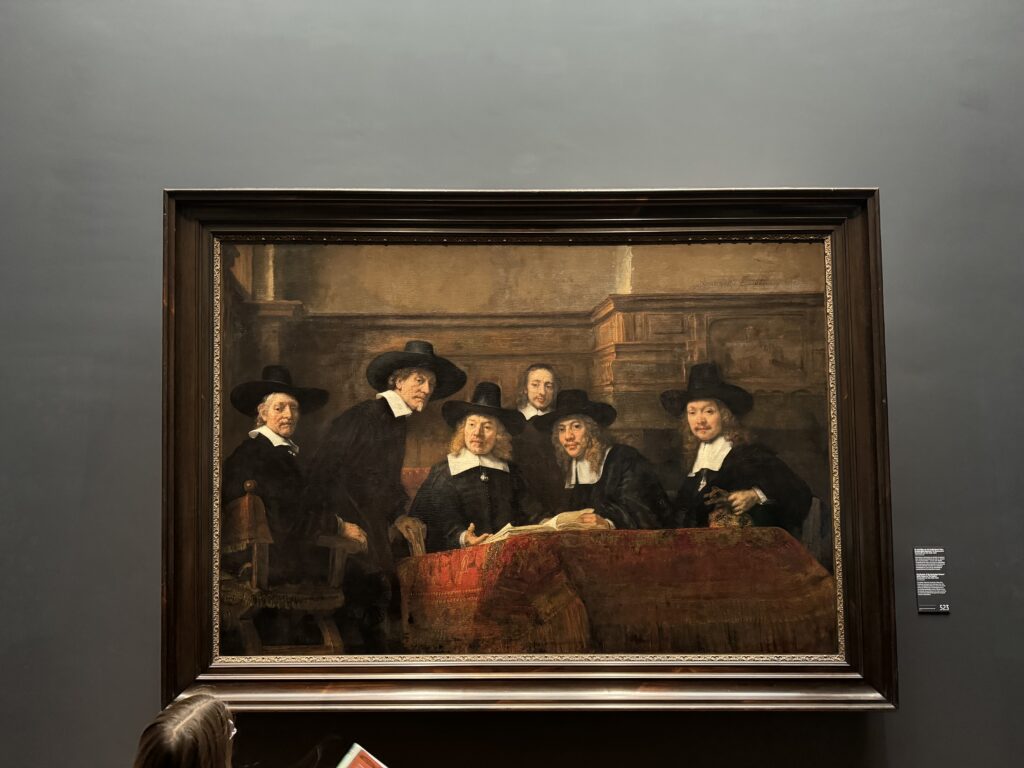 De Staalmeesters van Rembrandt, met een onbekende bezoeker